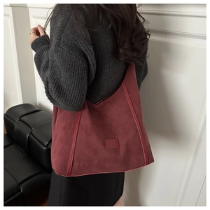 Detail view of burgundy faux suede tote bag with stylish vertical stitched texture