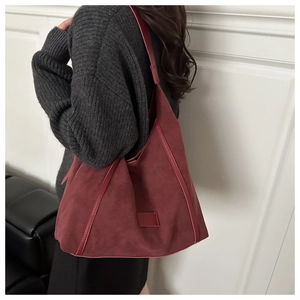 Side view of a burgundy suede hobo bag shown on model for a trendy autumn look