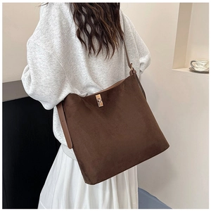 Detailed view of brown suede shoulder bag with elegant metallic turn-lock closure