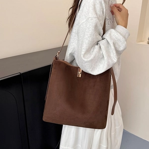 Minimalist brown suede tote bag with golden metal twist lock and slim shoulder strap