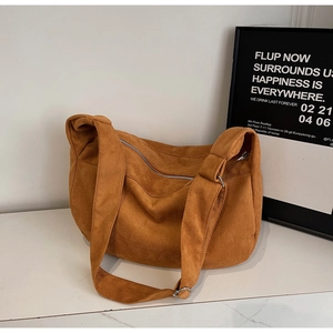Detail view of tan corduroy shoulder bag showing ribbed texture and metal buckle