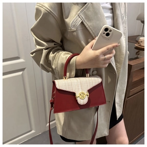 Detailansicht der rot-beigen Patchwork-Handtasche mit goldener M-Buchstabenschnalle