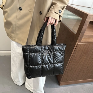 Chic black quilted puffer tote bag for women with glossy finish and snap closure