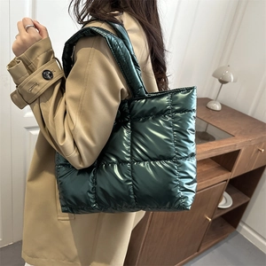 Deep green quilted tote bag with metallic finish shown on model in cozy interior