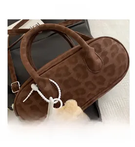 Macro shot of leopard print barrel bag featuring suede texture and cute bear charm detail