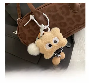 Detail of cute plush cartoon charm with striped legs hanging on leopard print bag