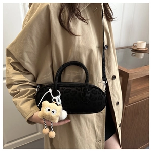 Dettaglio mini borsa leopardata con ciondolo a orsetto di peluche e tracolla nera