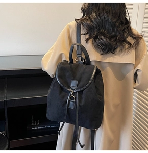 Detailed back view of a black frosted texture backpack on model with drawstring design
