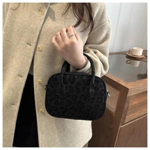 Détail d'un sac à main léopard porté par un mannequin en manteau de laine beige