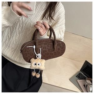 Brown leopard print pillow bag with plush monster charm and stylish double handles