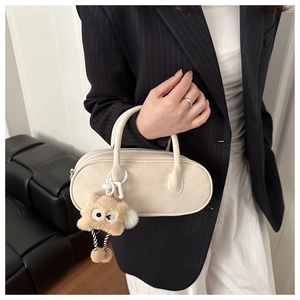 Borsa bowling chic in pelle bianco crema con un simpatico ciondolo mostro di peluche marrone