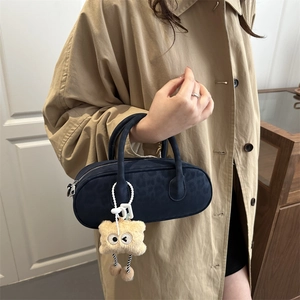 Borsa a cilindro leopardata blu navy con ciondolo a mostro e trench di colore khaki