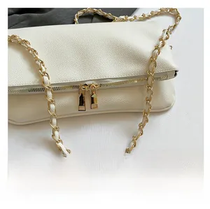 Close-up of white lychee-patterned leather bag with elegant gold chain and double zipper