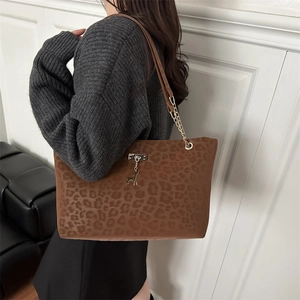 Leopard print tote bag with gold deer charm and leather chain strap shown on model