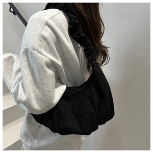Détail du sac hobo noir en daim à grande capacité avec bandoulière à volants et plis
