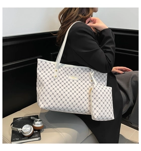 Side view of white tote bag with geometric print and matching pouch on a model