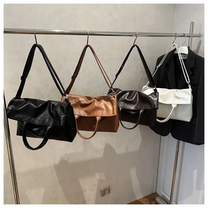 Dettaglio di quattro borse tote in pelle testurizzata nei colori nero, caramello e beige