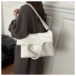 Dettaglio borsa tote bianca texture litchi con manico e tracolla indossata dalla modella