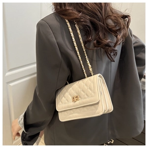Détail du sac bandoulière matelassé blanc cassé avec chaîne dorée et plis accordéon