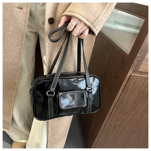 Detail of vintage black patent leather shoulder bag with white contrast stitching