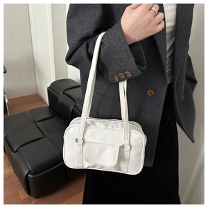 Detail view of a white leather rectangular handbag with an external flap pocket design