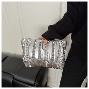 Close-up of a silver quilted clutch bag with metallic texture and vertical pleats