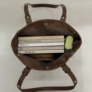 Vista verticale dell'interno di una grande borsa tote in pelle marrone con ampia capacità