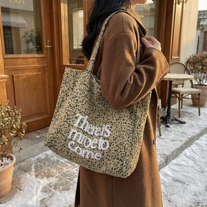 Winter-ready leopard print canvas tote bag with letter print shown in a street style scene