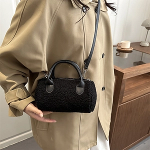 Elegant black plush cylinder crossbody bag with leather handles and silver hardware for winter
