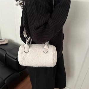 Fashionable white faux shearling cylinder handbag with leather straps and silver hardware
