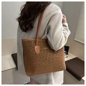 Détail de la texture léopard et du logo métallique sur le sac fourre-tout chic