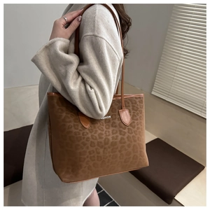 Detail of leopard print tote bag with FASHION text and brown leather shoulder straps