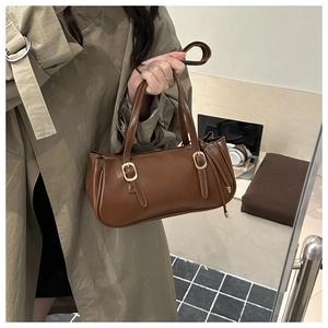 Détail du sac sous l'aisselle marron avec des boucles dorées décoratives élégantes