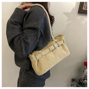 Detail of vintage suede shoulder bag with metal buckle and long strap for women