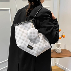 Chic grey and white checkered tote bag with matching round coin purse shown on a model