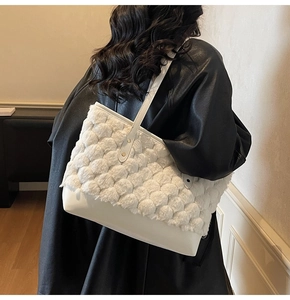 Detail view of a white plush tote bag with woven texture on a black coat back background
