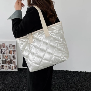 Silberne gesteppte Tote Bag mit Metallic-Finish und breiten Trägern am Modell
