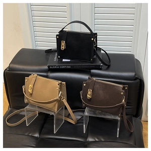 Three minimalist crossbody handbags in black, brown, and khaki with gold hardware