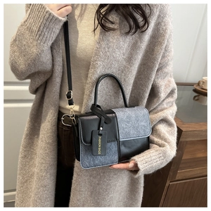 Detail of a chic patchwork crossbody bag featuring grey tweed and black leather textures