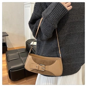Detail of camel PU leather underarm bag with metal buckle and suede patchwork design