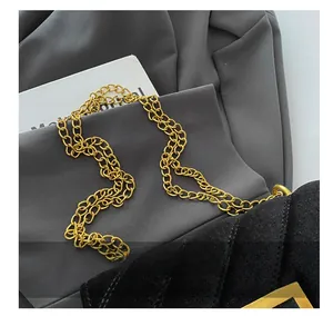 Close-up of black velvet crossbody bag with luxury gold chain strap and metal buckle