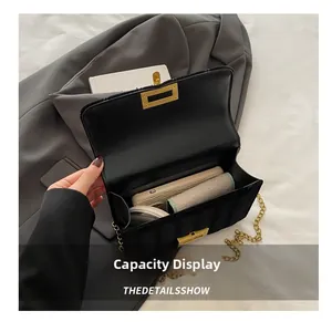 Interior view of black quilted chain bag showing capacity for phone and makeup