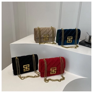 Detail view of four velvet quilted crossbody bags in gold, blue, black, and red colors