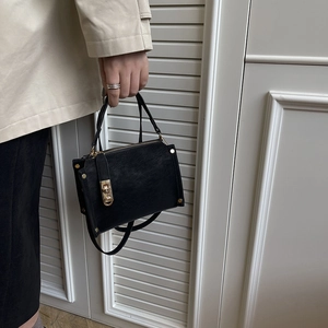 Retro black crossbody bag with textured leather, gold studs, and metal turn-lock closure