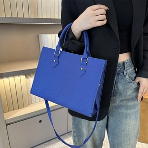 Borsa tote blu reale con manici e tracolla mostrata in un ambiente professionale elegante