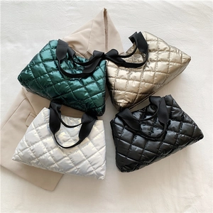 Stylish quilted tote bags with metallic finish in four colors on a minimal background