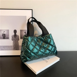 Glossy dark green quilted tote bag with black straps and stylish puffy diamond stitching