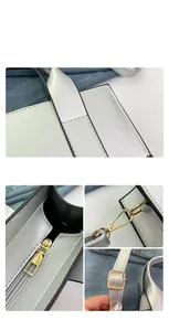 Macro detail of the silver handbag showing precise stitching, golden hooks, and metal zipper