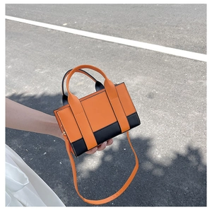Close-up of a mini contrast color tote bag with sturdy handles and a sleek orange finish