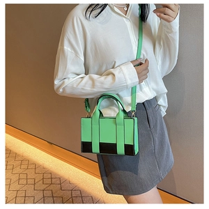 Crossbody small square bag in green and black contrast leather worn by a model